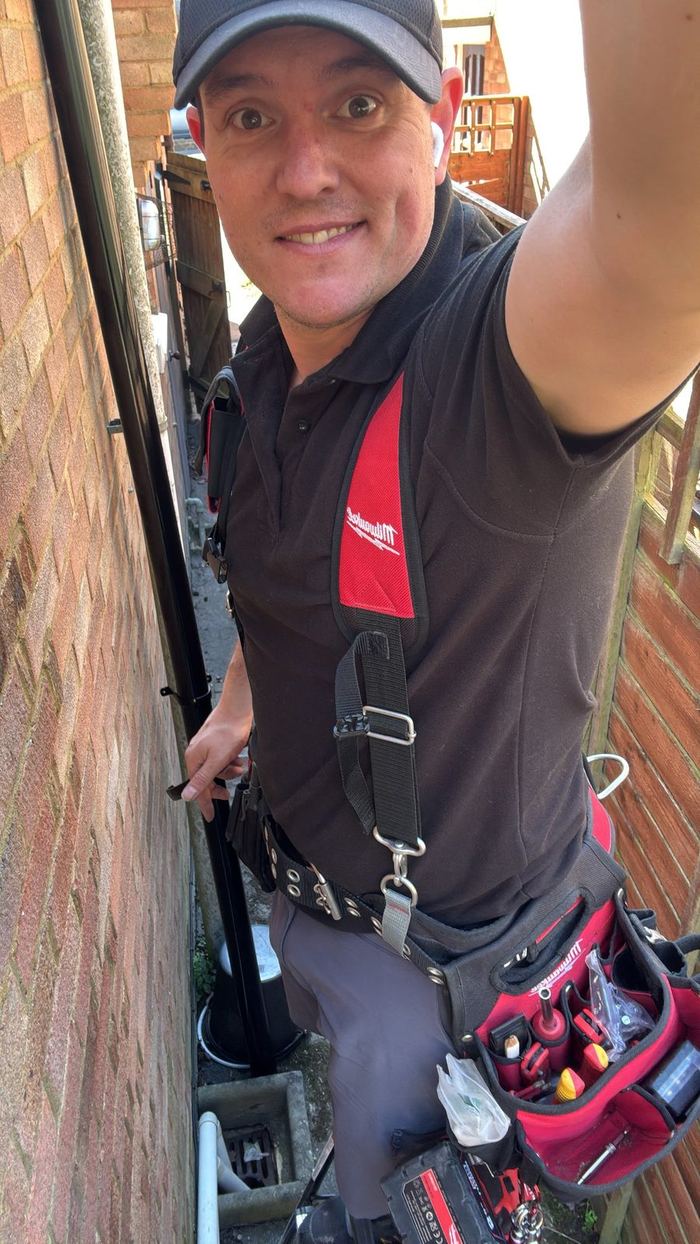 Sander fitting a downpipe on a local job